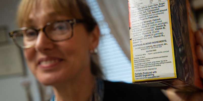 Jane Kolodinsky holding box with GMO label