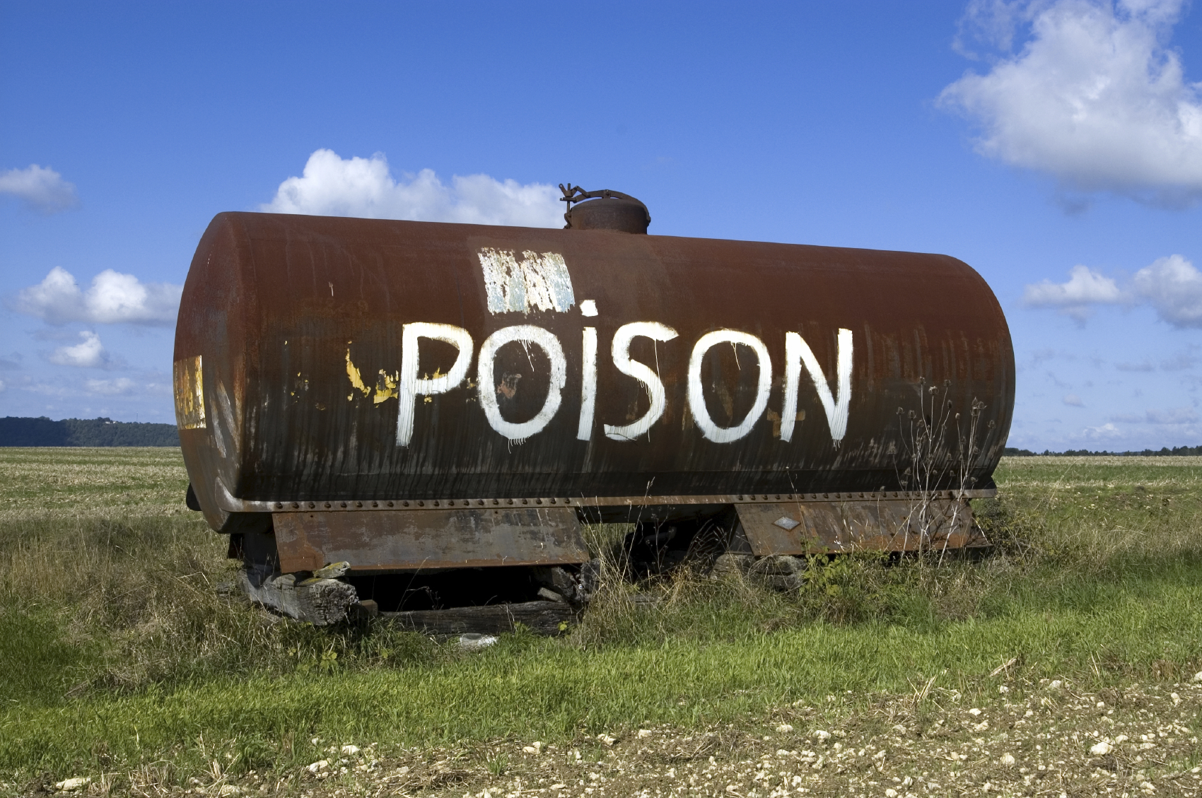 Poison painted on container in field