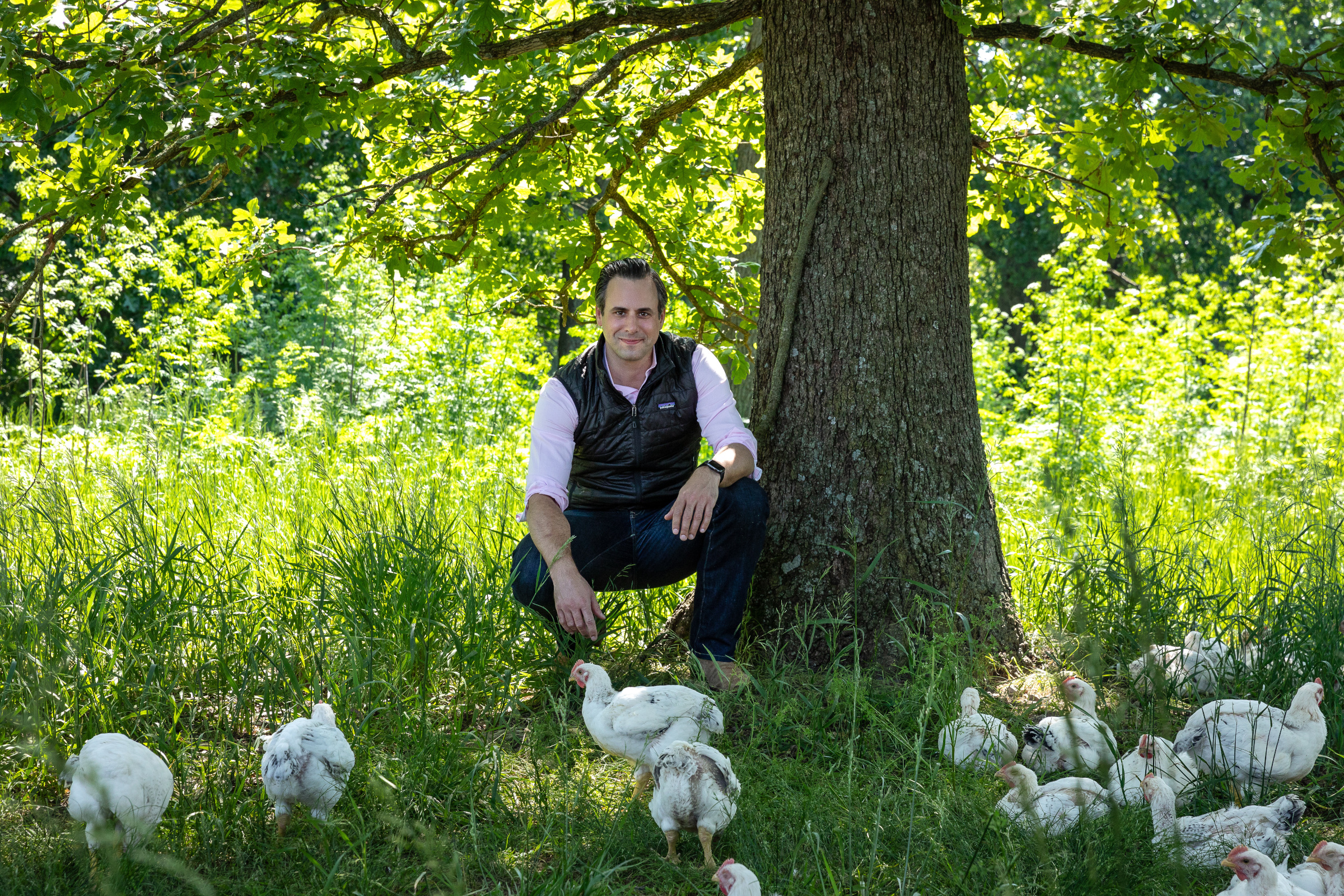 Cooks Venture founder in field with chickens